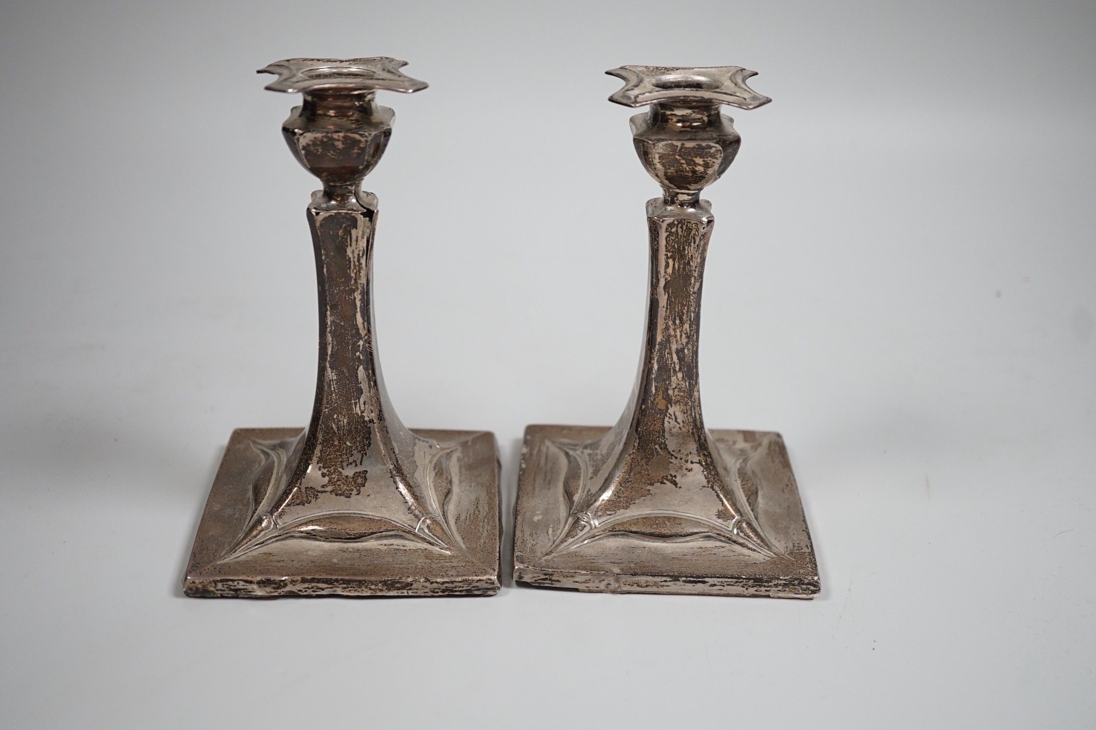 A pair of early 20th century Art Nouveau silver mounted candlesticks, marks rubbed (a.f.), height 15.2cm.